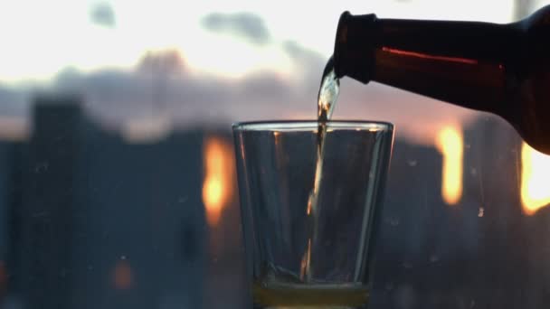 Bier Wordt Een Kort Glas Gegoten Tegen Een Onscherp Raam — Stockvideo