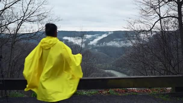 Una Niña Impermeable Amarillo Para Frente Puente Levantando Mano Para — Vídeos de Stock