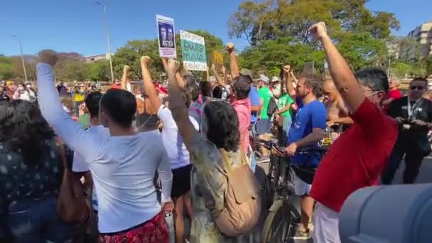 Protesting Crowd Stands One Arm Raised Fists Clenched Amazon Killings — Video