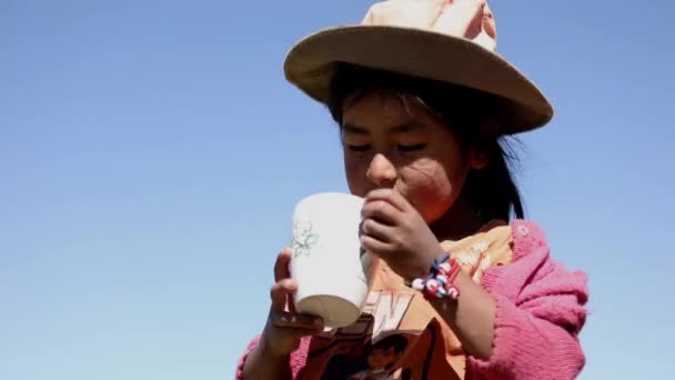 安第斯山脉一所乡村学校的一位可爱的女孩喝着杯子里的水 — 图库视频影像