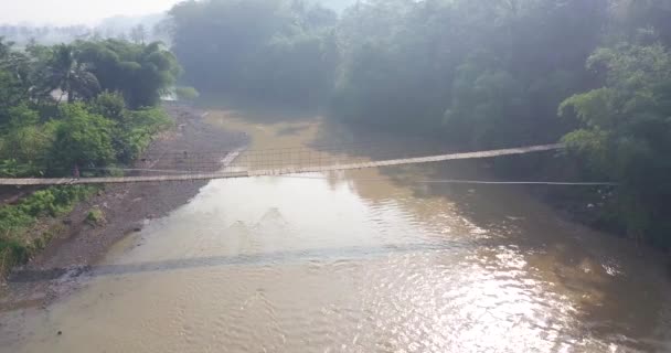 Drone Shot Suspension Bridge River Motorcycle Crossing Morning Sun Ray — Wideo stockowe