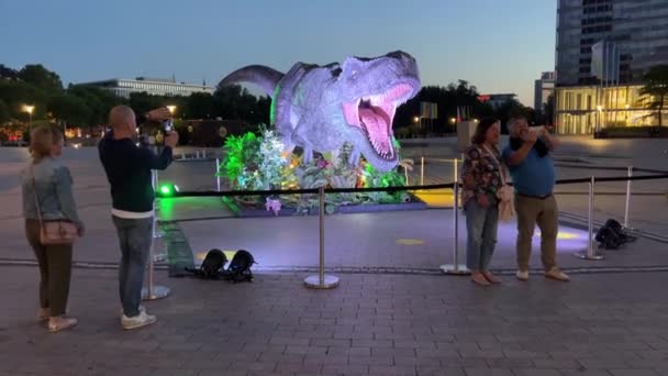 Orang Orang Mengambil Gambar Dengan Dekorasi Dinosaurus Depan Bioskop Setelah — Stok Video