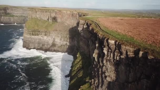 莫赫悬崖上的田野和大西洋上的浪花汹涌 爱尔兰 无人侦察机在空中鸣枪 — 图库视频影像