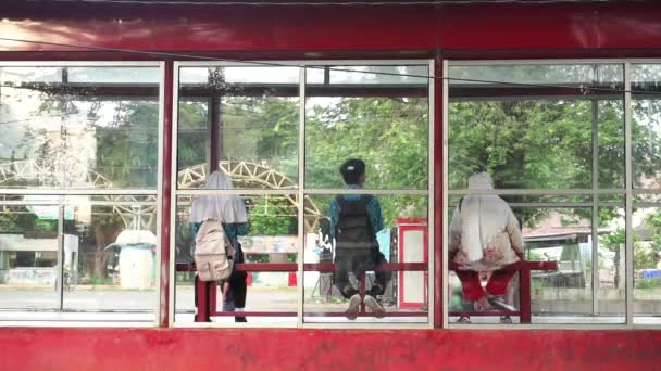 Studenten Und Mutter Sitzen Langen Stühlen Der Bushaltestelle Und Passieren — Stockvideo