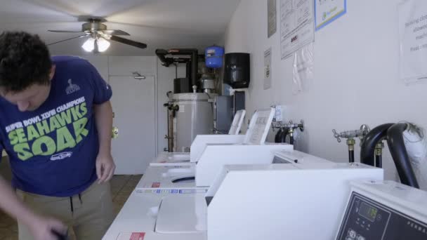 Man Loading Dirty Laundry Washing Machine Apartment Complex — Vídeo de stock