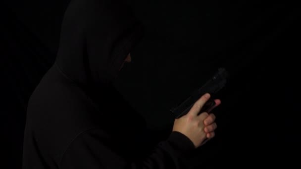 Hombre Encapuchado Con Una Pistola Mano Oscuridad — Vídeo de stock