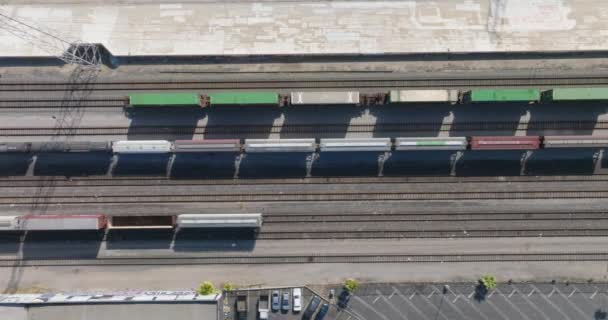 軌道に沿って移動する列車のバードスアイドローンビュー Laレール市内を通って高速道路の車の下を移動します — ストック動画