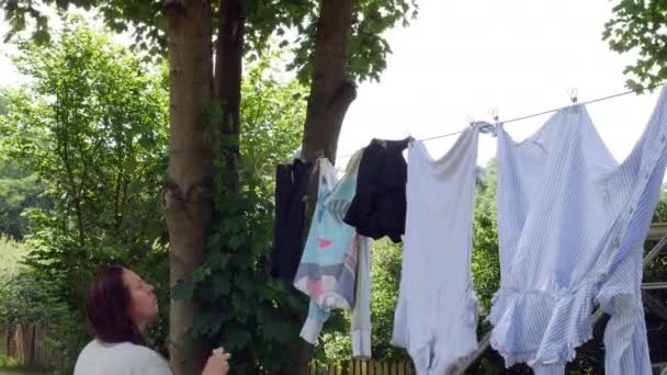 Uma Mulher Pendurado Lavanderia Uma Linha Lavagem Com Estacas Jardim — Vídeo de Stock