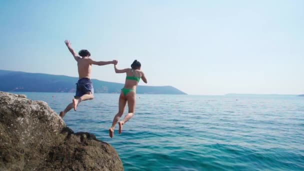 Young Couple Swimwear Jumping Huge Rock Vast Blue Sea Slow — ストック動画