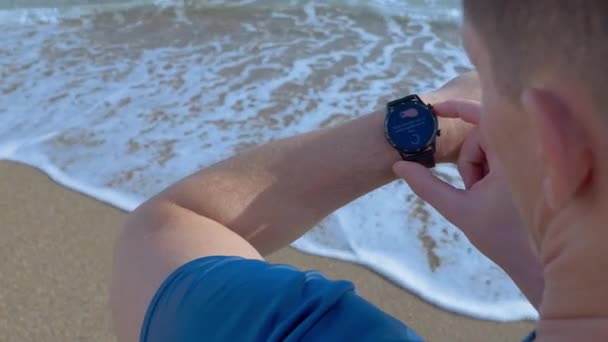 Ένας Νεαρός Καυκάσιος Κοντά Μαλλιά Χρησιμοποιεί Συνδεδεμένο Ρολόι Του Πατώντας — Αρχείο Βίντεο