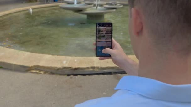 Mladý Běloch Krátkými Hnědými Vlasy Vyfotil Fontánu Svým Smartphonem Uprostřed — Stock video