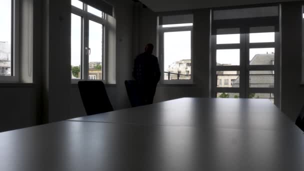 Silhouette Male Talking Mobile Walking Back Forth Unlit Empty Meeting — Video