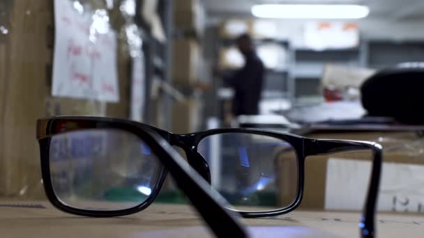 Close View Black Rim Glasses Resting Carboard Box Bokeh Background — 图库视频影像