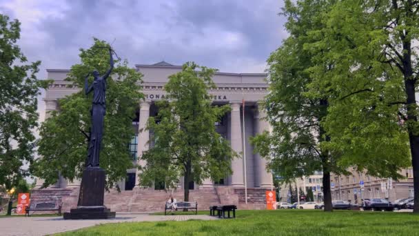 立陶宛 Martynas Mavydas Vilnius国家图书馆和Zinia雕塑的长椅上坐着一位妇女 广博的全景 — 图库视频影像