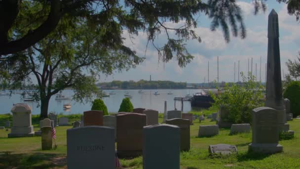 佩勒姆公墓 布朗克斯 美国国旗旁边的墓碑 与船和烟囱哈特岛的背景 — 图库视频影像