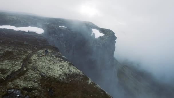 Aerial Male Standing Dramatic Cliff Edge Mist Rolling Norway Dolly — Stockvideo