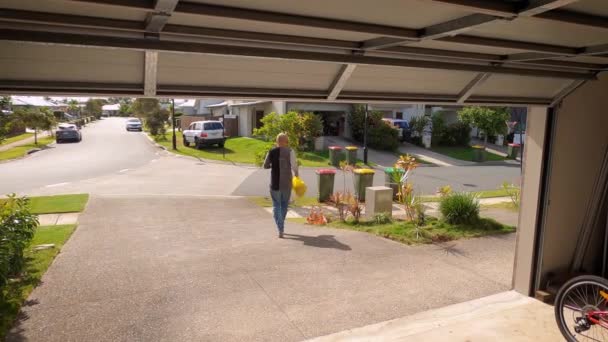 Man Urgently Walks His Driveway Carrying Plastic Garbage Collection Truck — Stock Video