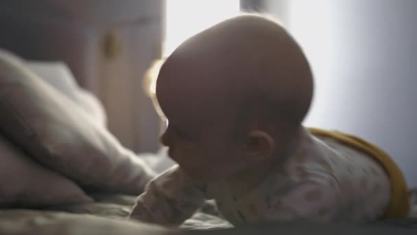 活动滚动婴儿在床上 背光射击 — 图库视频影像