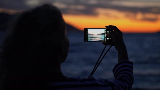 Mladá Žena Fotografuje Ohromující Oranžový Západ Slunce Nad Oceánem Svým — Stock video