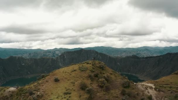 Aerial Forward Flight Showing People Standing Mountaintop Watching Epic Crater — ストック動画