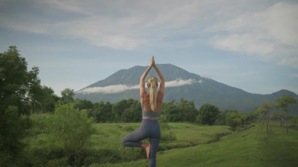 Athletic Blond Woman Yoga Tree Pose Balancing Rock Mount Agung — Stockvideo