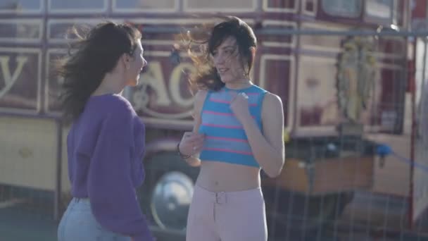 两名年轻女子坐在溜冰鞋上聊天跳舞 半身中弹 — 图库视频影像