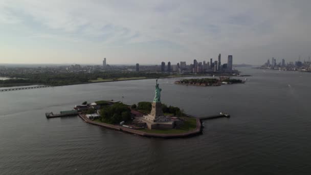 ニュージャージーとマンハッタンのスカイラインを背景に自由の女神の周りの空中ビューニューヨーク ドローンショット — ストック動画