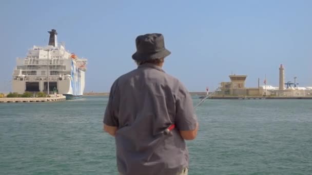 Egy Öregember Fekete Horgászruhában Egy Dél Franciaországi Város Kikötőjében Áll — Stock videók