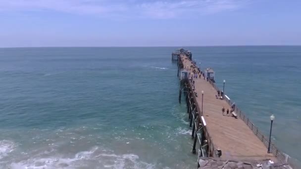 People Walking Pier Oceanside Aerial Drone Shot Flying Overhead Horizontal — Vídeos de Stock