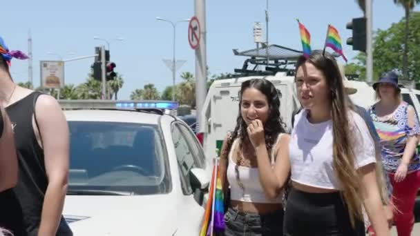 Friends One Wearing Rainbow Flags Hair Walking Police Patrol Car — ストック動画