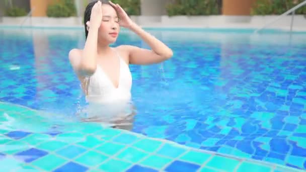泰国女性在游泳池洗澡的时候挤出湿湿的头发 她在水里一直游到胸部 摸着湿湿的头发 — 图库视频影像