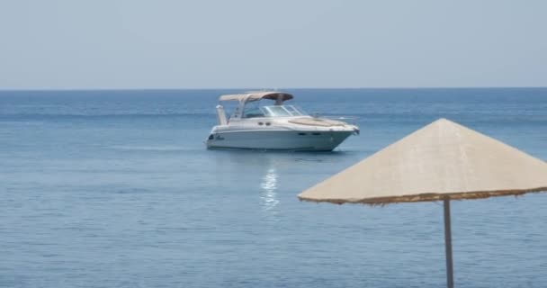 在希腊圣托里尼 白沙滩 阿克罗蒂里海滩的海岸线上 游艇漂浮在靠近老年夫妇的海面上 — 图库视频影像