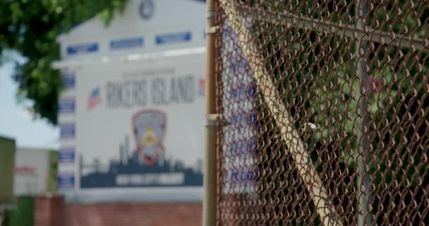Rack Fokus Från Kedja Länk Staket Till Rikers Island Fängelsetecken — Stockvideo