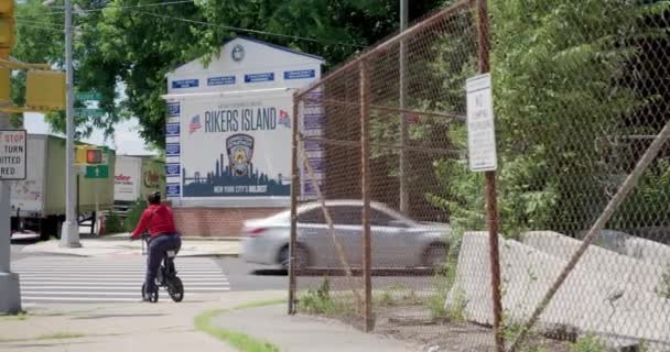 Woman Rides Electric Scooter Rikers Island Jail Sign Nyc — ストック動画