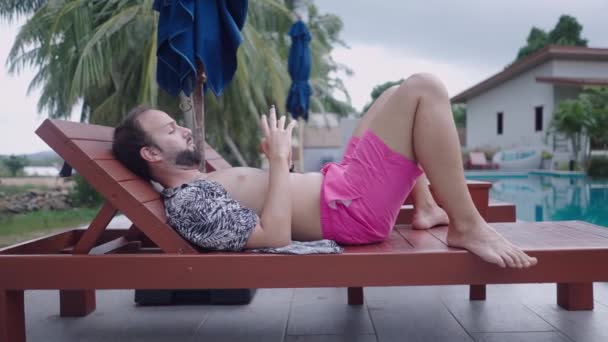 Bearded Man Traveler Watching Video Phone While Resting Wooden Deckchair — Stockvideo