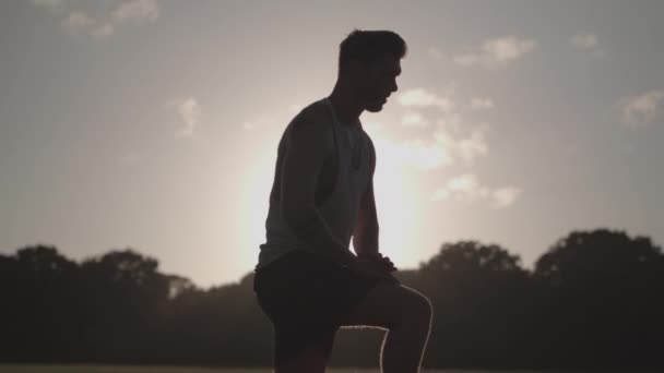 Hombre Estirando Sus Piernas Antes Una Carrera Mientras Silueta Por — Vídeos de Stock