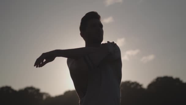 Man Stretches Works Out Whilst Being Silhouetted Evening Sun Slow — Vídeos de Stock