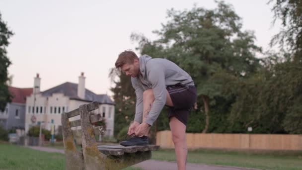 Young Athletic Man Ties His Shoes Bench Park Sets Run — Stock video