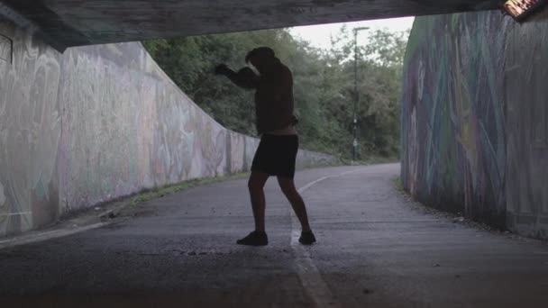 Wide Shot Young Athletic Man Boxing Underpass Silhouetted Light Him — Stockvideo