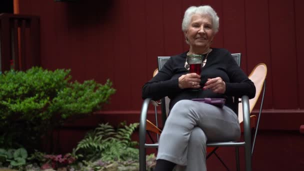 Elderly Woman Smiling Sitting Garden While Drinking Red Wine — Video