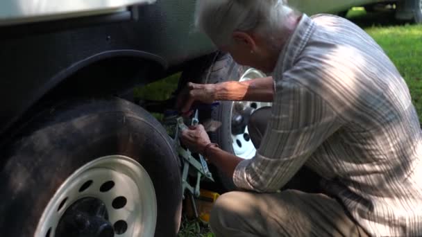 Крупный План Пожилой Женщины Откручивающей Шину Запирающей Шину Фургоне — стоковое видео