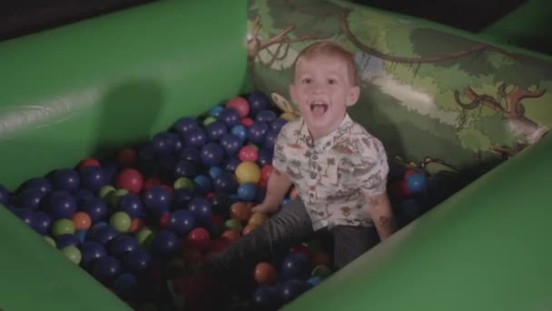 Young Boy Playing Ball Pit Smiling Throwing Balls Ungraded — Stock Video