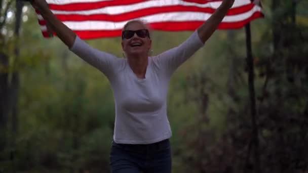 Pretty Mature Woman Wearing Sunglasses Smiling Plays American Flag Waving — Vídeos de Stock