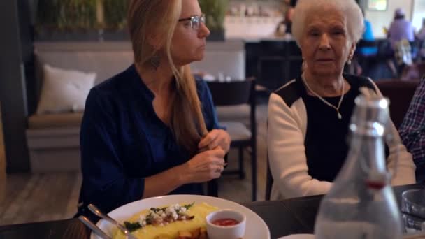 Blonde Woman Eating Omelet Talking Elderly Woman Restaurant — Stockvideo