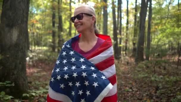 Smiling Blonde Woman Walking Forest Flag Wrapped Her — Vídeo de Stock