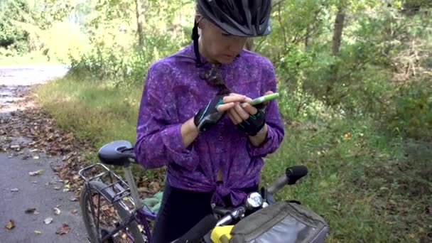 Mature Woman Wearing Biking Helmet Gloves Straddling Her Bike Checking — 图库视频影像