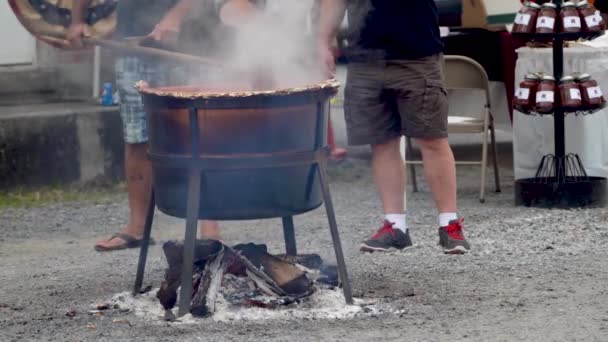Two Men Standing One Them Stirs Steaming Apple Butter Large — Stockvideo