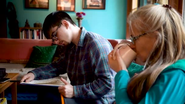 Mother Drinks Tea Her Son Reads School Assignment Out Textbook — Stockvideo