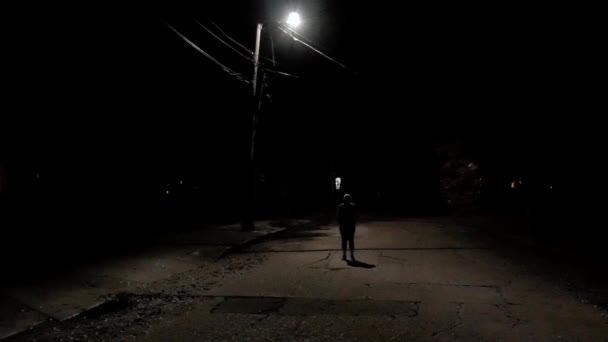 Slow Panning Shot Unidentified Person Standing Dark Shadows City Streetlight — стоковое видео