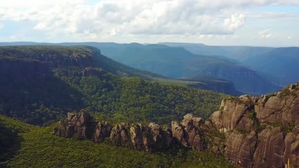 Drone Turning Arc Revealing Large Rock Structure Cliffs Mountains Background — Stock Video